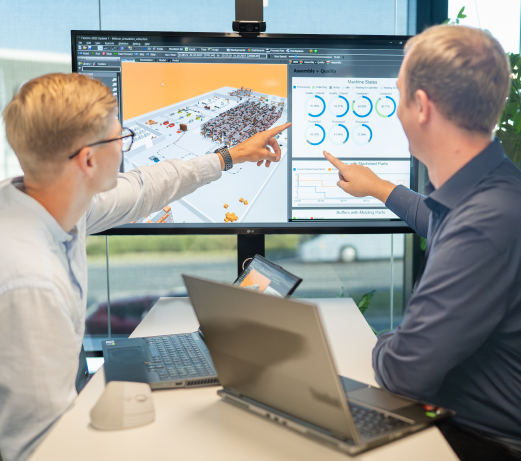 Dva specialisté Aimtec ověřují návrh automatizace skladu pomocí simulačního softwaru